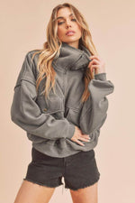 Model wearing Aemi + Co Exposed Seam Half Zip Sweatshirt with Pockets in grey, paired with black shorts for a casual look.