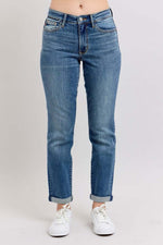 Judy Blue mid rise skinny cuff jeans with pockets in blue wash, styled with white sneakers for a casual look.