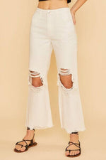 White distressed raw hem jeans featuring edgy rips and frayed edges for a trendy street-style look.