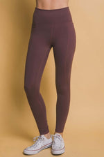 Burgundy high waist leggings with side pockets, perfect for workouts and casual outings, paired with stylish white sneakers.