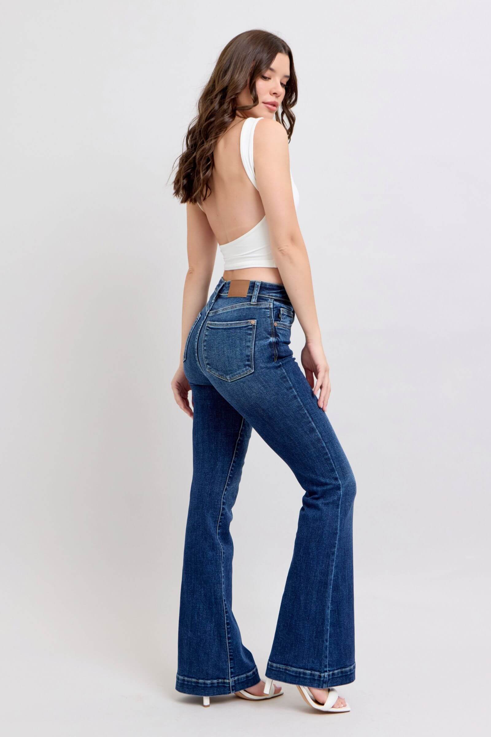 Model showcasing Judy Blue high-rise flare jeans with pockets, featuring a chic fit and retro style from the back.