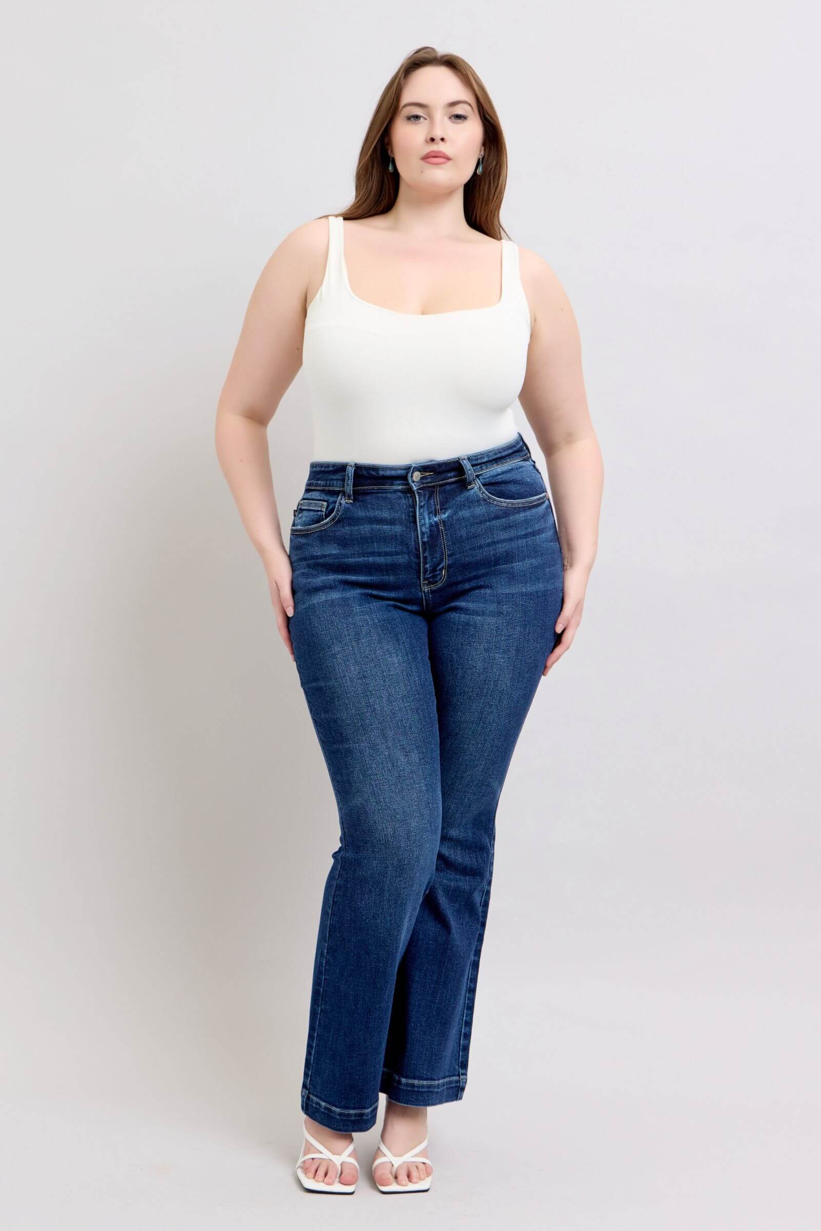 Judy Blue plus size high rise flare jeans with pockets, model wearing casual outfit, trendy denim style.