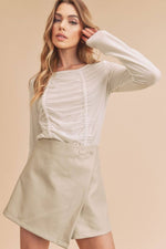 Model wearing Aemi + Co Ruched Front Long Sleeve T-Shirt with cream skirt for a chic, stylish look.