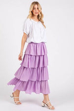 Elegant model wearing a lavender chiffon ruffle layer midi skirt paired with a white top and stylish sandals.