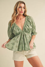 Chic green eyelet embroidered V-neck half sleeve peplum blouse paired with shorts for a stylish look.