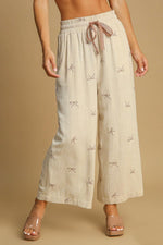 Umgee plus size wide-leg pants with lace drawstring and embroidered bows for elegant comfort.