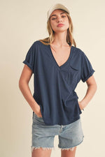 Model wearing Aemi + Co Side Slit V-Neck Short Rolled Sleeve T-Shirt in navy with casual denim shorts.