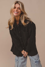 Smiling model wearing BiBi Button Up Washed Jacket in black, showcasing stylish pockets and a casual look.