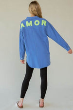 Back view of Davi & Dani Letter Back Raw Hem Half Button Shirt featuring 'AMOR' in bright letters.