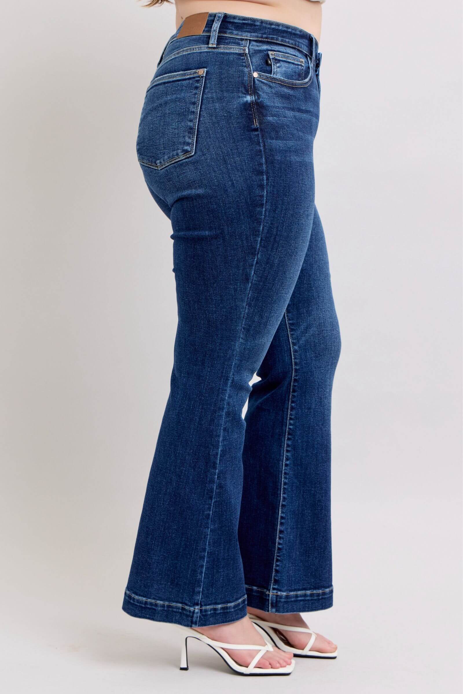 Side view of Judy Blue full size high rise flare jeans with pockets in dark wash, showcasing trendy silhouette and chic style.