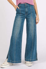 Woman wearing Mittoshop Medium Wash Wide Leg Denim Jeans with seam detail, styled casually with a pink top and sneakers.