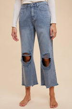 Distressed raw hem jeans featuring ripped details and a trendy, edgy street-style look. Perfect for casual outfits.