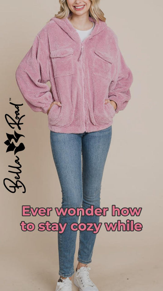 Cozy pink faux fur zip-up hoodie with side pockets, perfect for chilly days and casual wear.