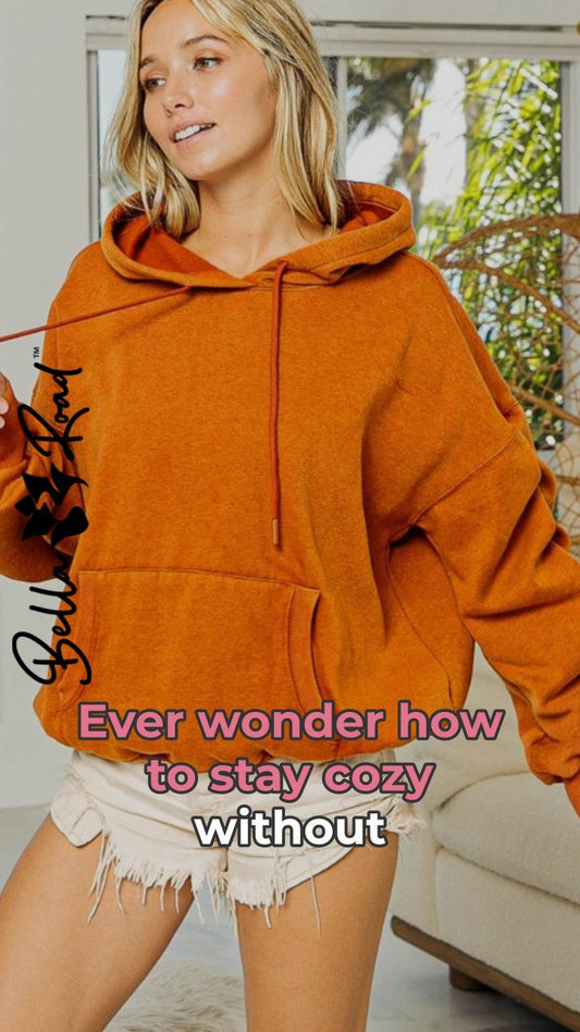 Model wearing a cozy orange BiBi Ruched Long Sleeve Hoodie, perfect for staying warm and stylish.