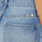 Close-up of high waist chewed up straight mom jeans with a vintage-inspired, edgy style and distressed details.