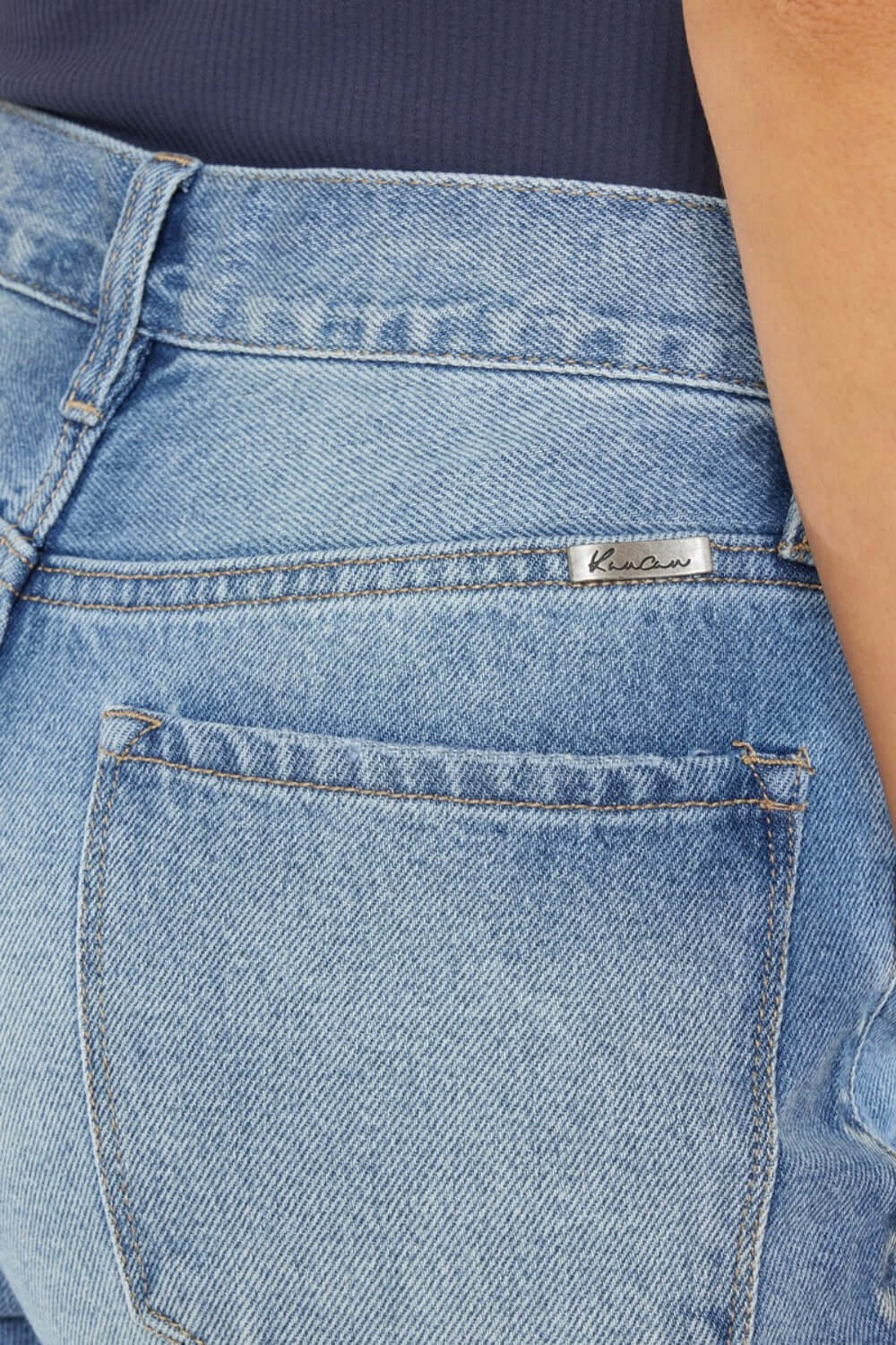 Close-up of high waist chewed up straight mom jeans with a vintage-inspired, edgy style and distressed details.