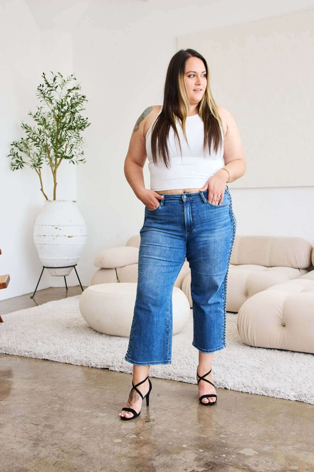 Woman modeling Judy Blue wide leg jeans with braid side detail, showcasing trendy and stylish design.