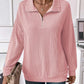 Woman wearing a striped half zip pink long sleeve t-shirt with a slightly stretchy, opaque fabric made of polyester, rayon, and elastane.