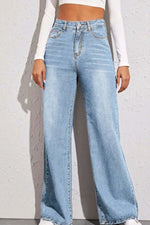 Woman wearing high waist wide leg jeans with a basic style, made of 65% cotton and 35% polyester, standing against a white textured wall.