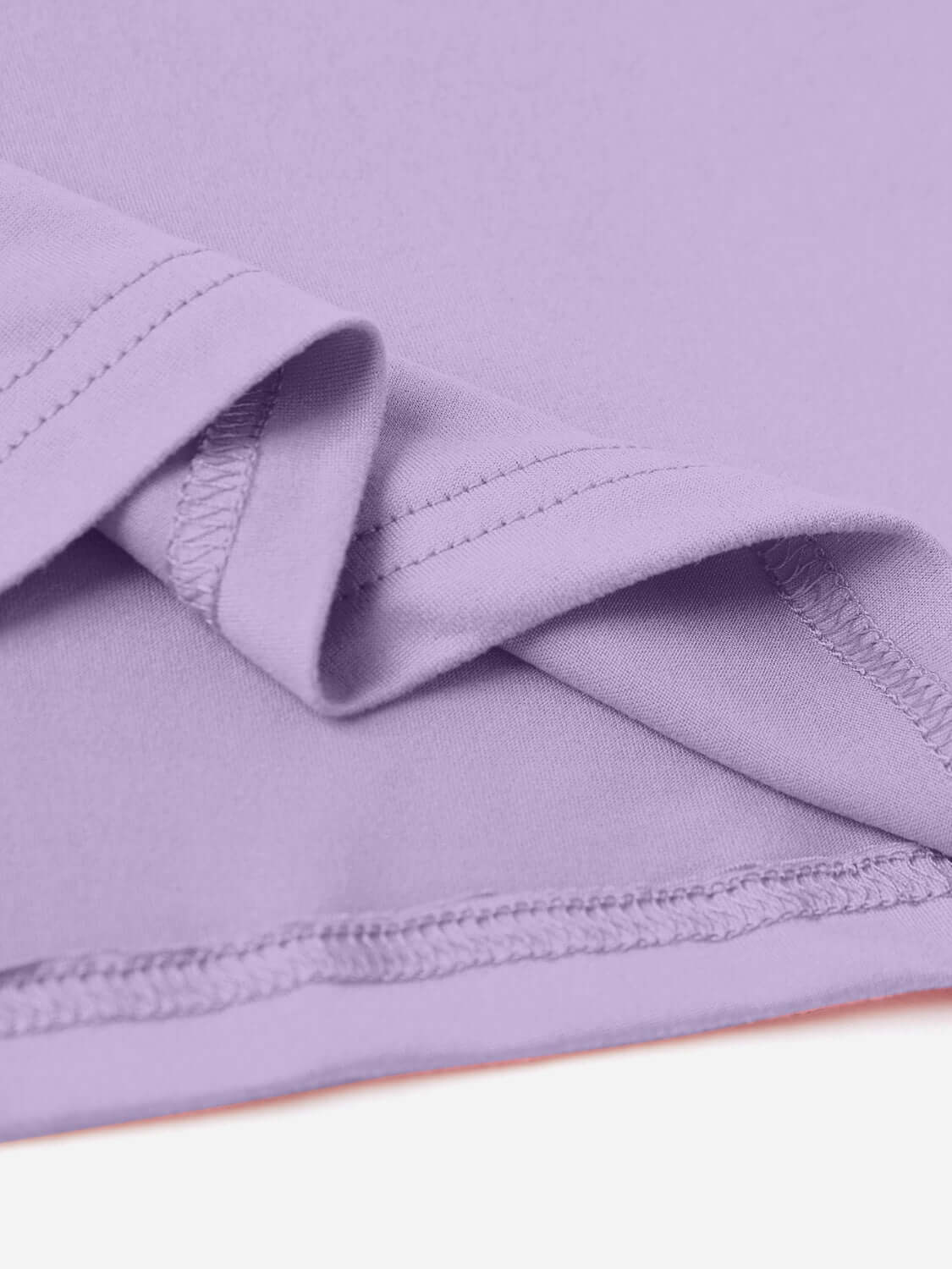 Close-up of purple graphic round neck short sleeve t-shirt fabric showing stitching details and slightly stretchy material