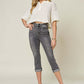 Woman wearing Judy Blue Jeans button fly high waist cuffed capris and a white top