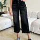 Woman wearing High Waist Button Fly Jeans in black, showcasing stylish and trendy design with button fly closure.