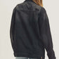 Back view of RISEN distressed long sleeve denim jacket, styled with casual shorts for a trendy look.