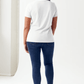 Woman wearing a white Simply Love Graphic Round Neck Short Sleeve Tubular T-Shirt and jeans, viewed from the back.