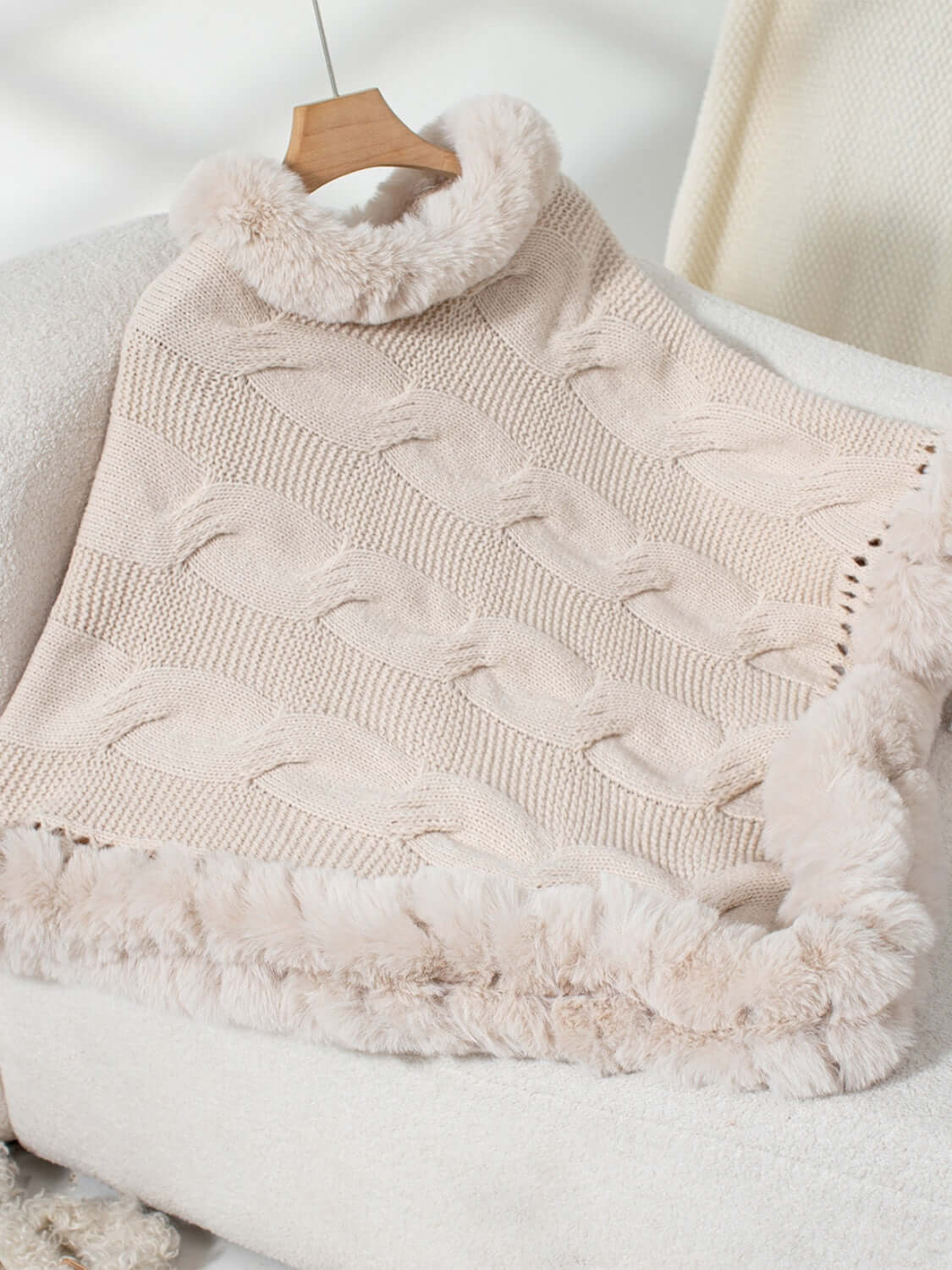 Cozy Bella Road Fuzzy Hem Cable-Knit Poncho in soft beige, featuring luxurious cable-knit design and fluffy trim. Perfect for chilly days!