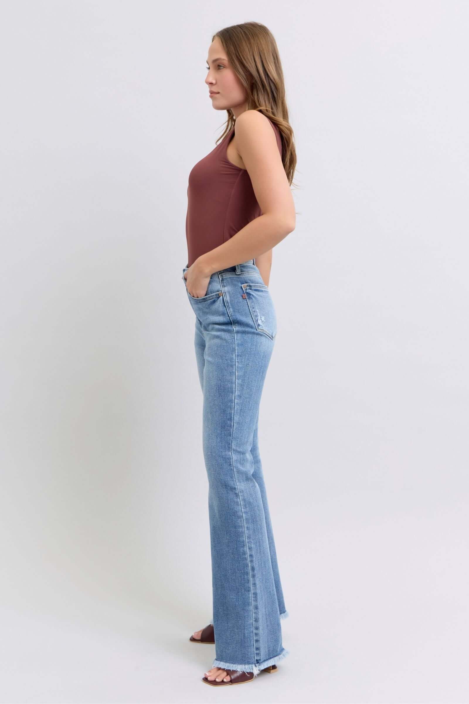 Stylish model showcasing Judy Blue high rise bootcut jeans with raw hem, perfect for a trendy and flattering look.