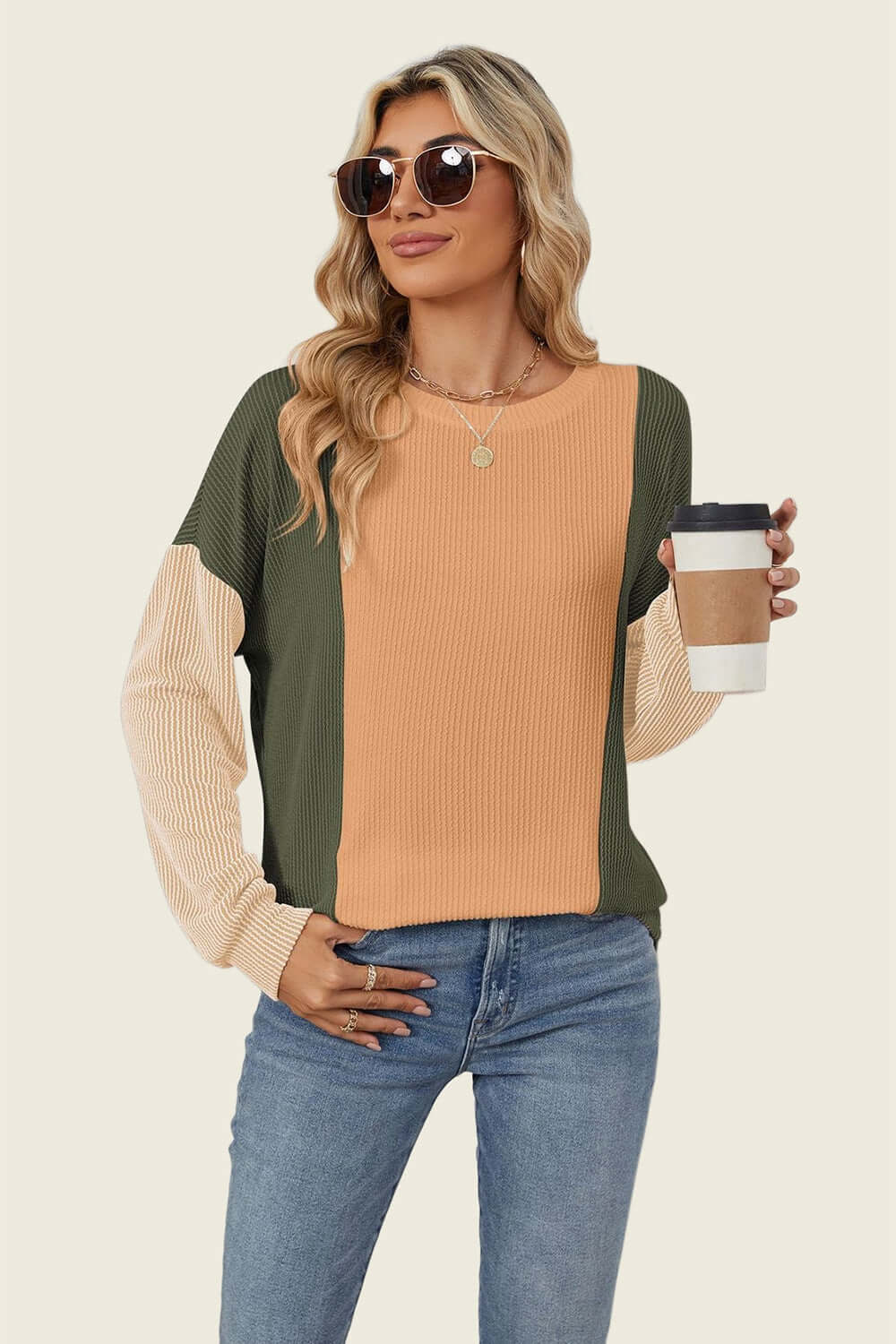 Stylish woman wearing Double Take Texture Contrast Round Neck Long Sleeve T-Shirt in trendy colors holding coffee cup.