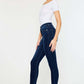 Woman wearing High Rise Frayed Ankle Skinny Jeans, side profile view showcasing the trendy ankle-length frayed hem and flattering high-waist fit.