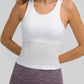 Woman wearing a white round neck racerback active tank top, showcasing comfort and style for workouts.