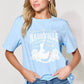 Woman wearing light blue graphic round neck short sleeve T-shirt with "Nashville Country Music" design