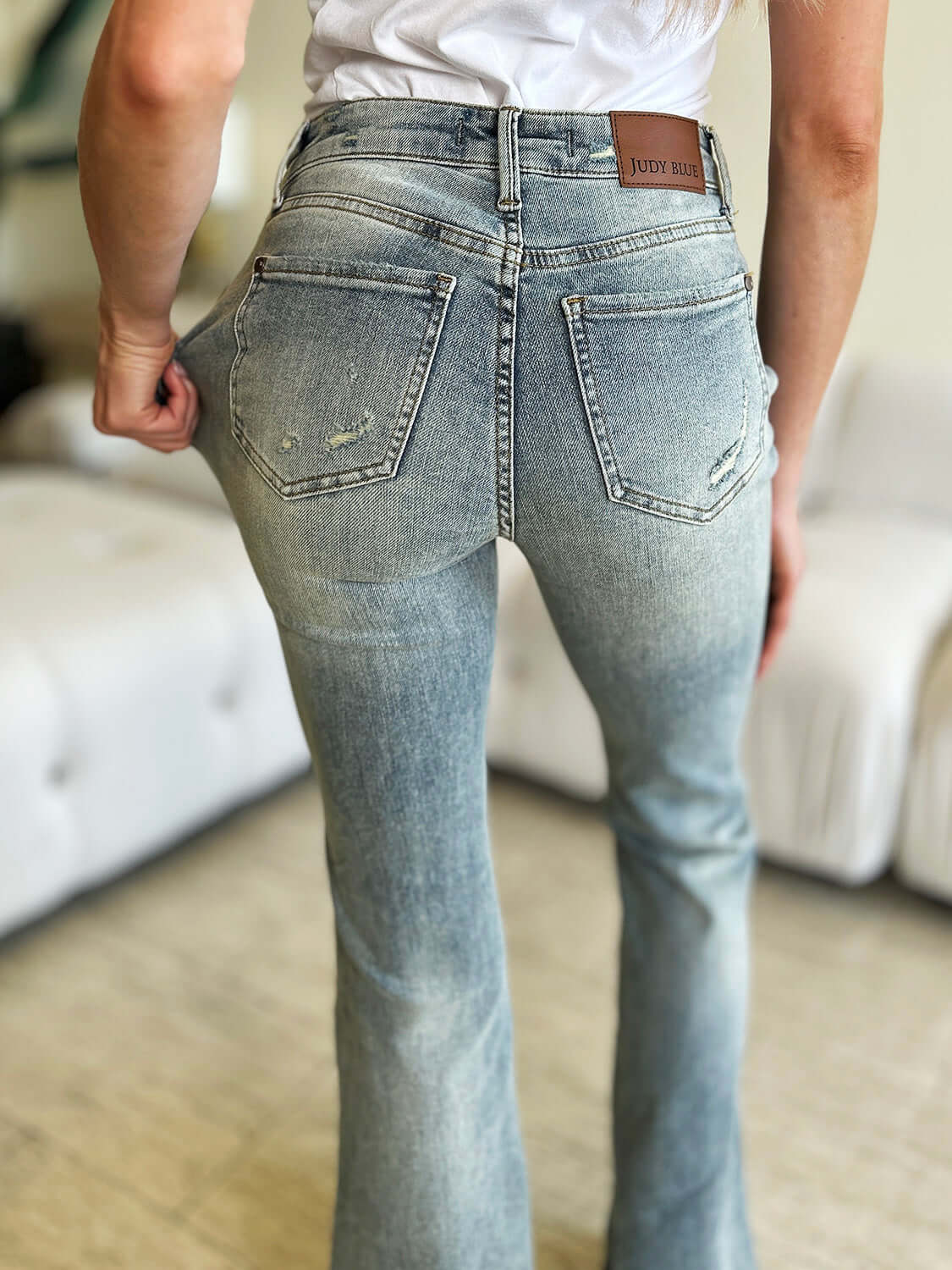 Woman wearing Judy Blue High Waist Flare Jeans showcasing back view of vintage-inspired denim with flare leg silhouette.