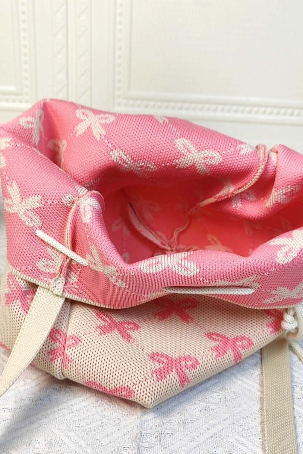 Pink and white Ribbon Bowknot Pattern Crossbody Bucket bag with open top showing interior.