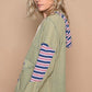 Woman wearing POL Star Patchwork Hoodie with raw edges and colorful striped hood, showcasing relaxed fit and chic design.