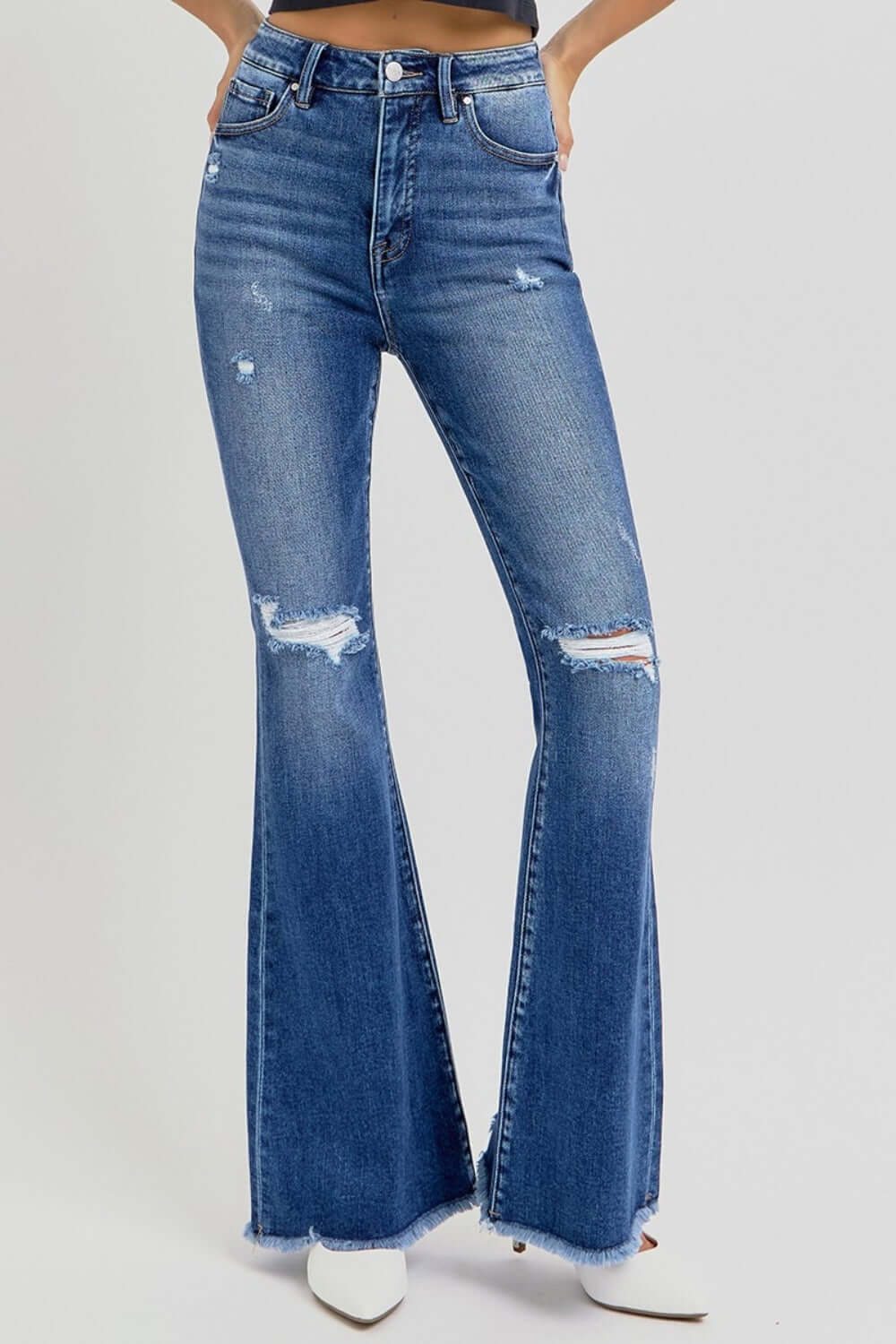 High-rise distressed flare jeans with raw hem, offering a trendy and retro style for a chic wardrobe update.