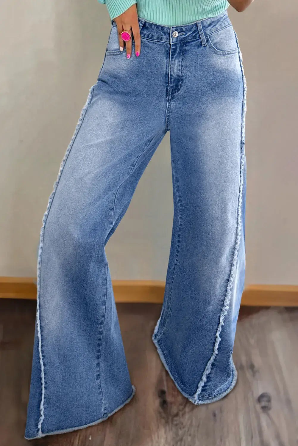 Woman wearing Bella Road Raw Hem Wide Leg Jeans with Pockets and slightly stretchy denim material for a stylish, playful look