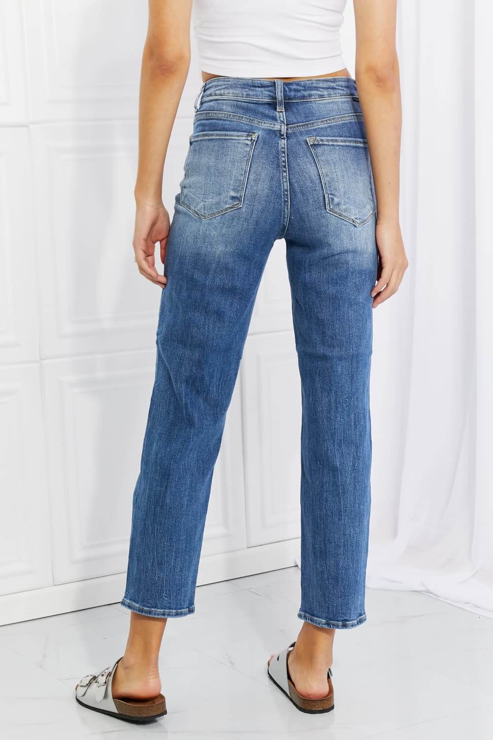 Back view of Emily High Rise Relaxed Jeans with ripped knees, featuring a cropped length, moderate stretch, and casual distressed style. Risen Jeans.