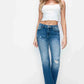 Woman wearing bytos Full Size Raw Hem Distressed Mid Rise Straight Jeans paired with a white crop top, showcasing youthful style.