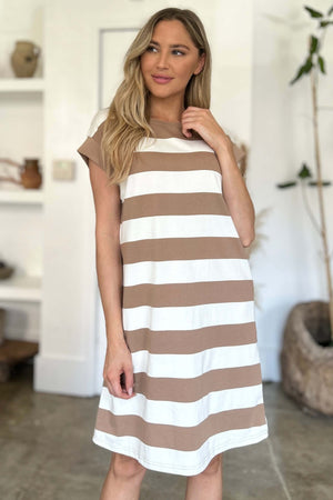 Woman wearing Basic Bae Full Size Striped Round Neck Cap Sleeve Mini Dress in white and brown stripes against a stylish indoor backdrop.