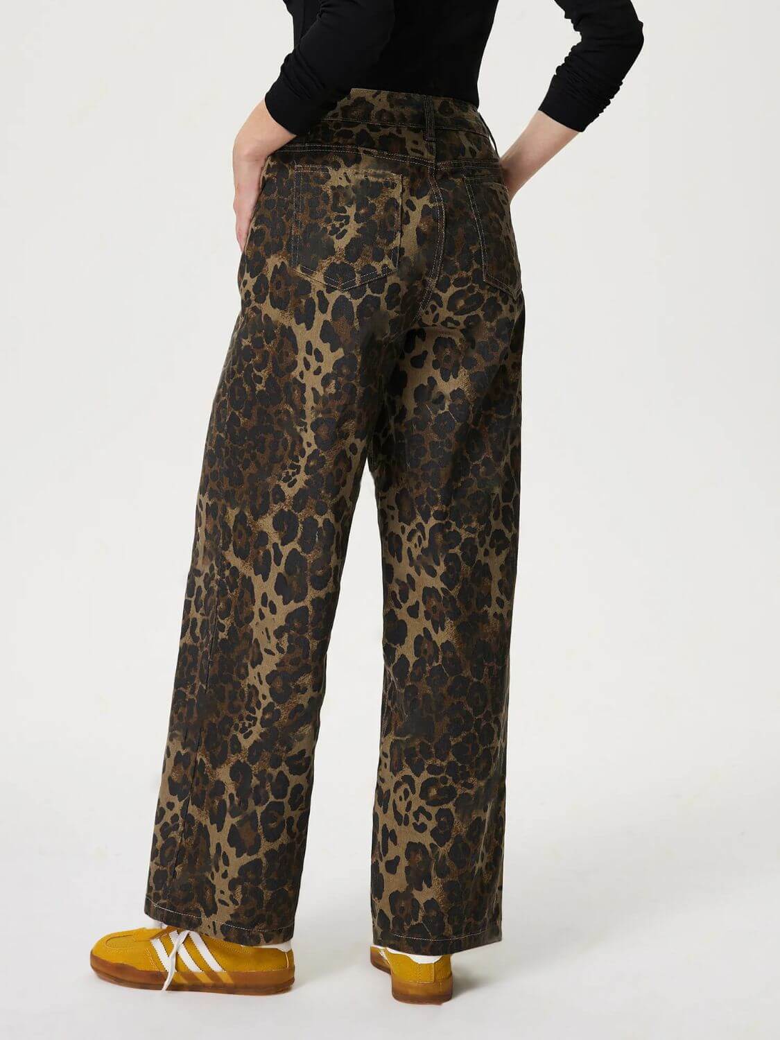 Woman wearing Bella Road Denim Leopard Straight Jeans, showcasing bold leopard print and classic straight leg cut from the back.