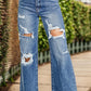 Distressed high waist bootcut jeans with ripped details, slightly stretchy denim perfect for a trendy, casual look.