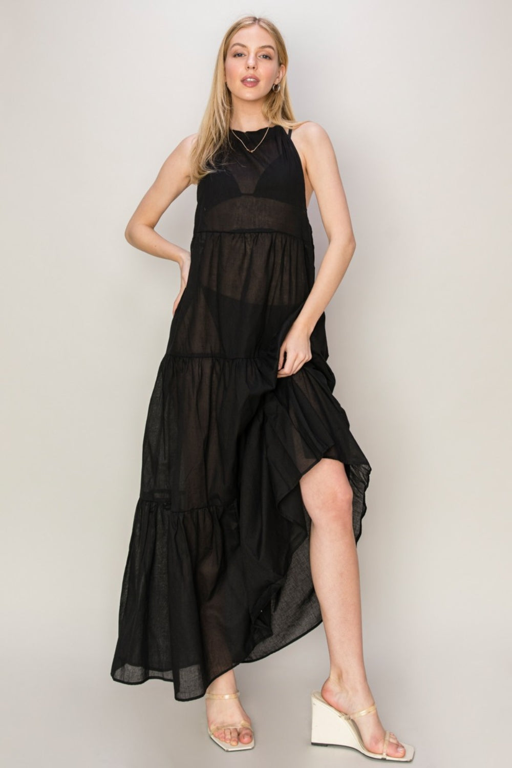 Elegant black halter neck cover-up maxi dress with tiered design, perfect for warm days or tropical getaways.