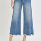 Woman wearing Risen Jeans high rise cropped flare jeans with a modern chic style, showcasing distressed details and frayed hems