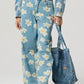 Model showcasing Bella Road denim pocketed floral wide leg jeans with a blue floral pattern and matching tote bag.