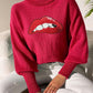 Red Bella Road Lip Turtleneck Sweater with bold lip graphic, worn by model against a light background