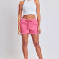 Woman wearing YMI Jeans drawstring raw hem shorts in pink, showcasing a trendy and relaxed style perfect for casual wear and lounging.