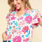 Woman wearing a notch neck sequin floral blouse with vibrant floral detailing, showing off its elegant and feminine design for a chic, modern look.